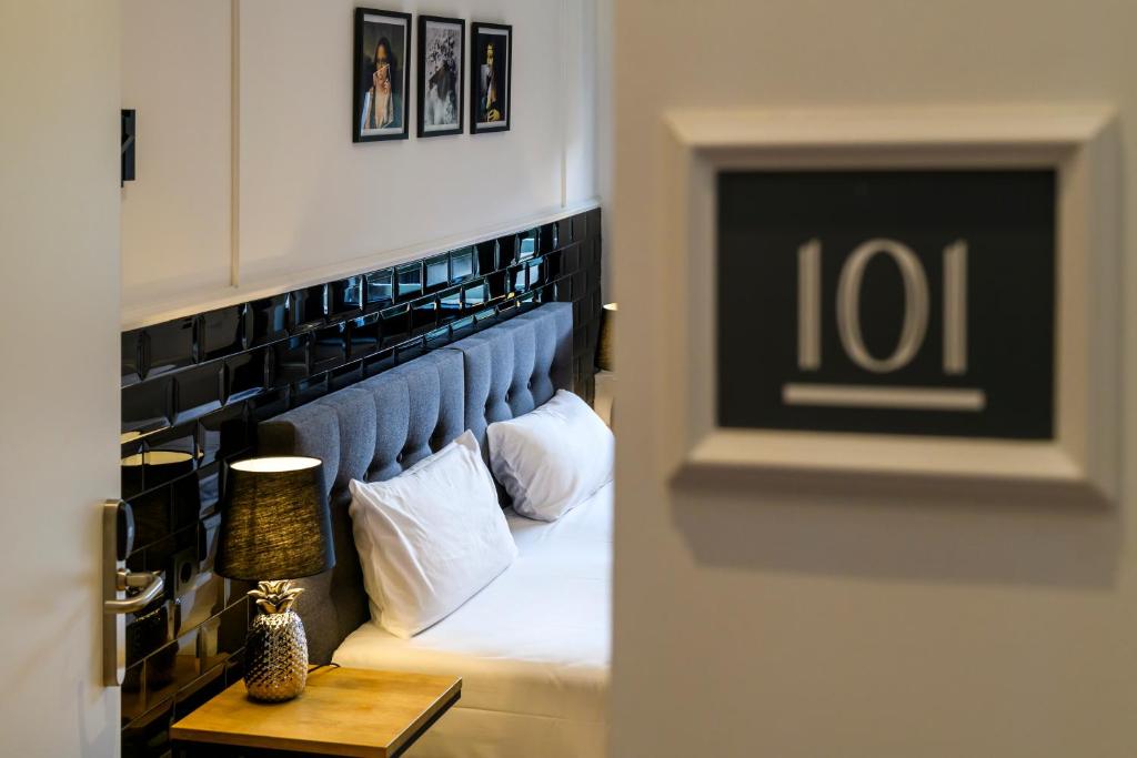 a bedroom with a bed with a blue head board at Nikii Boutique Hotel in Leverkusen