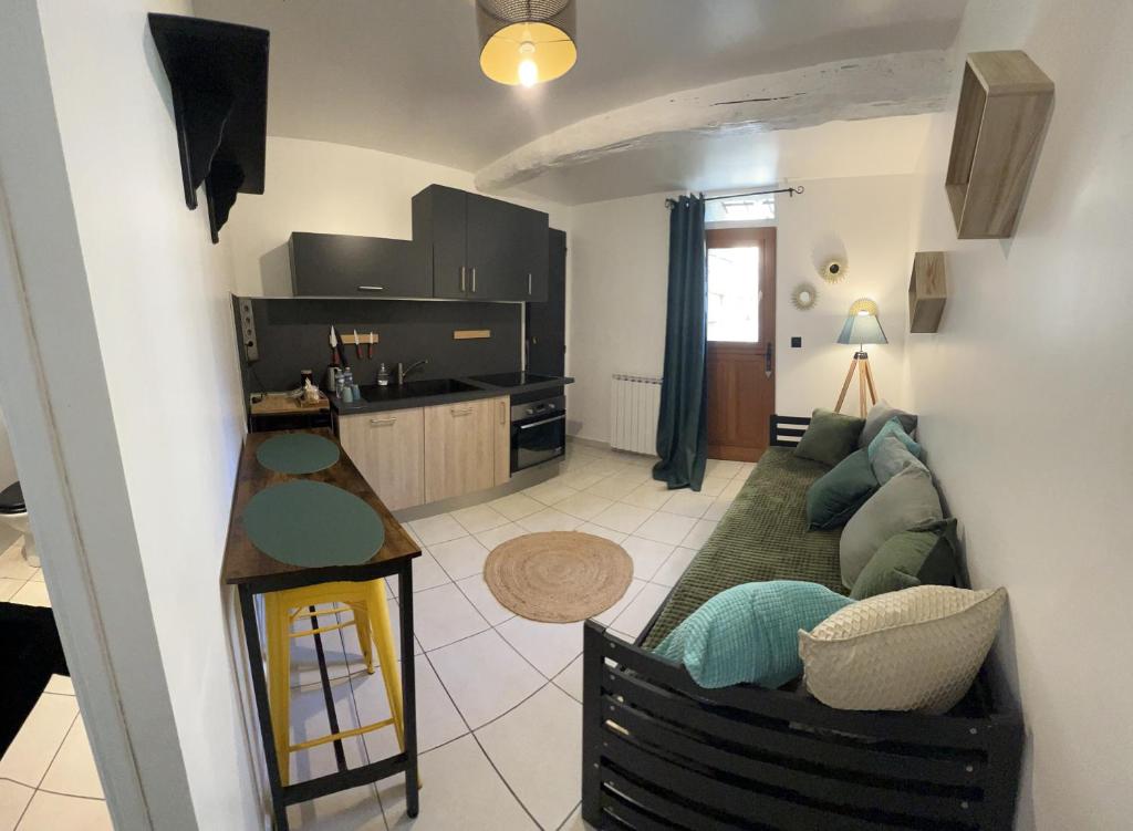 ein Wohnzimmer mit einem Sofa und einer Küche in der Unterkunft La Ferme de Valeuse in Morienval