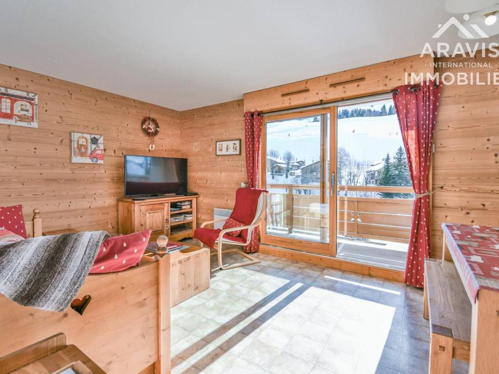 a living room with wooden walls and a large window at Appartement Le Grand-Bornand, 2 pièces, 4 personnes - FR-1-391-110 in Le Grand-Bornand