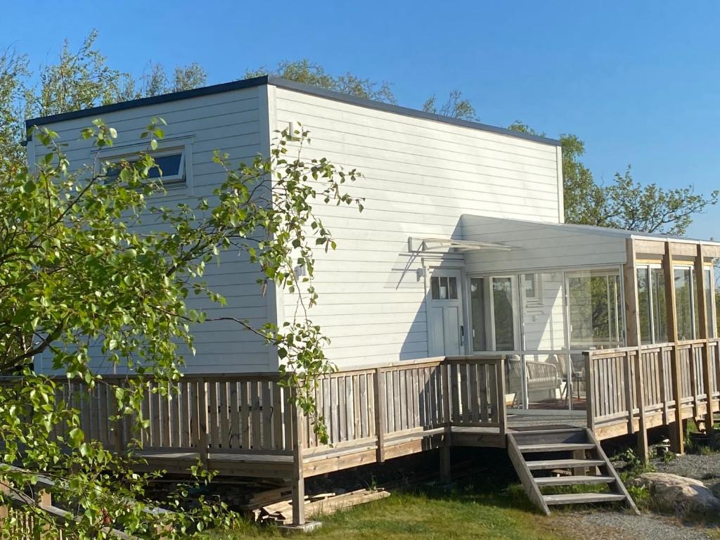 uma pequena casa com um alpendre e um deque em Mycket trevlig stuga på Brännö med havsutsikt em Brännö