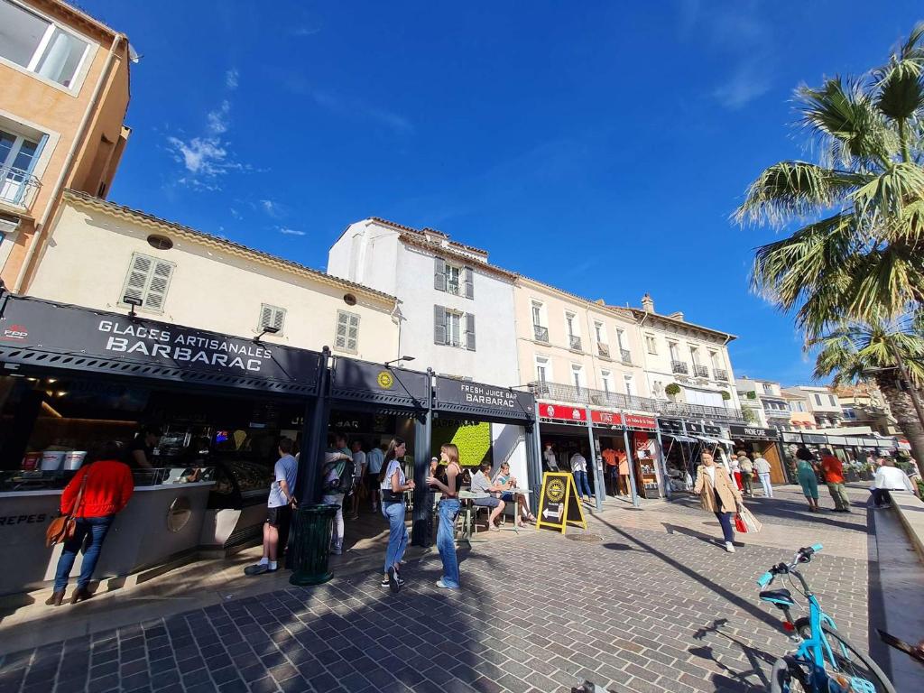 a group of people walking around a street with buildings at Appartement Sainte-Maxime, 2 pièces, 4 personnes - FR-1-226-500 in Sainte-Maxime