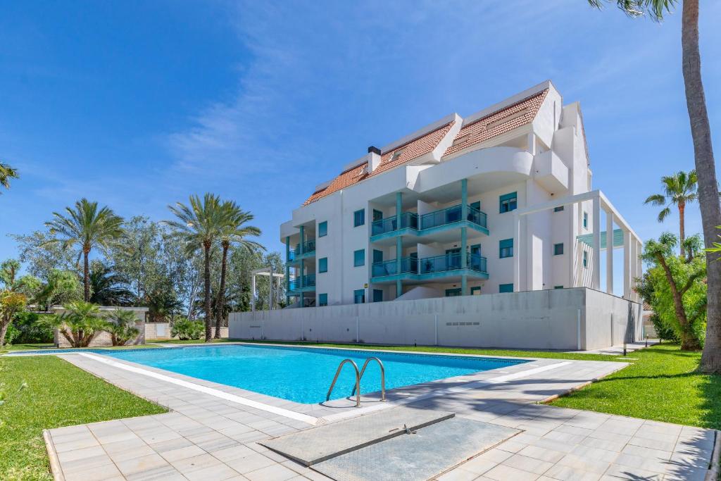 a villa with a swimming pool in front of a building at Pont Sec Apartments in Denia