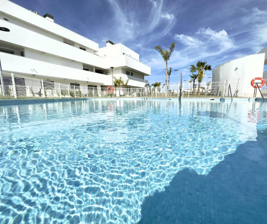 uma grande piscina em frente a um edifício em VILLAFLORES Home free parking by Cadiz4Rentals em Rota
