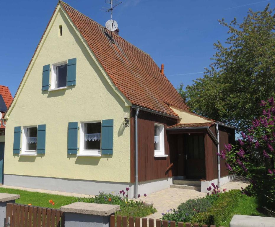 una casa con tetto marrone e persiane blu di Ferienhaus Jurablick a Thalmässing