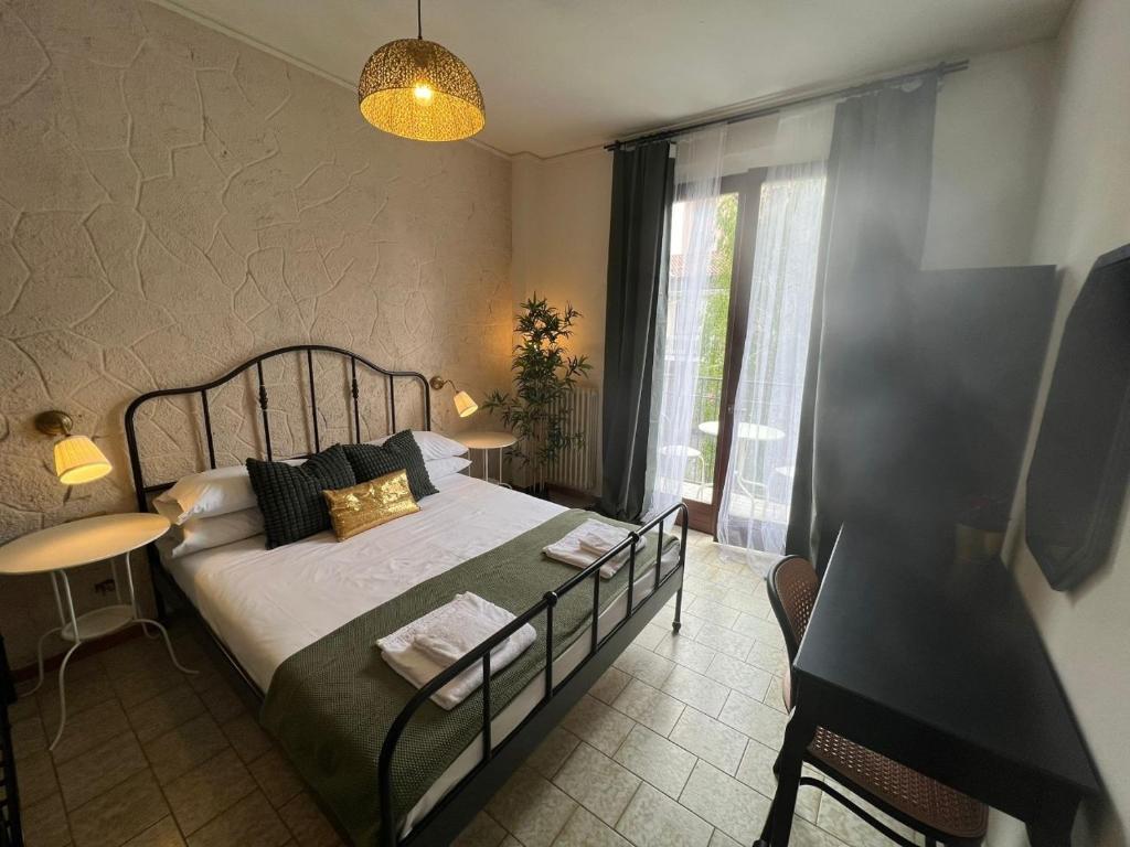 a bedroom with a bed and a table and a window at Ambra Boutique Hotel in Milan