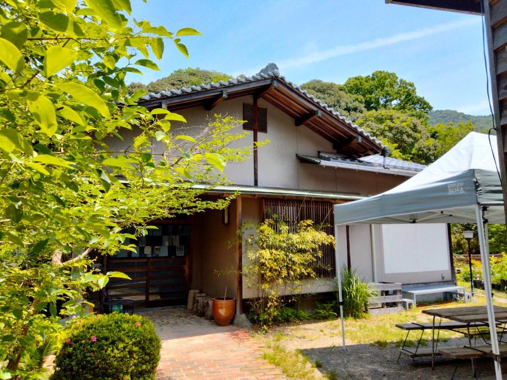 dom ze stołem i namiotem przed nim w obiekcie 88 House Hiroshima w mieście Hiroszima