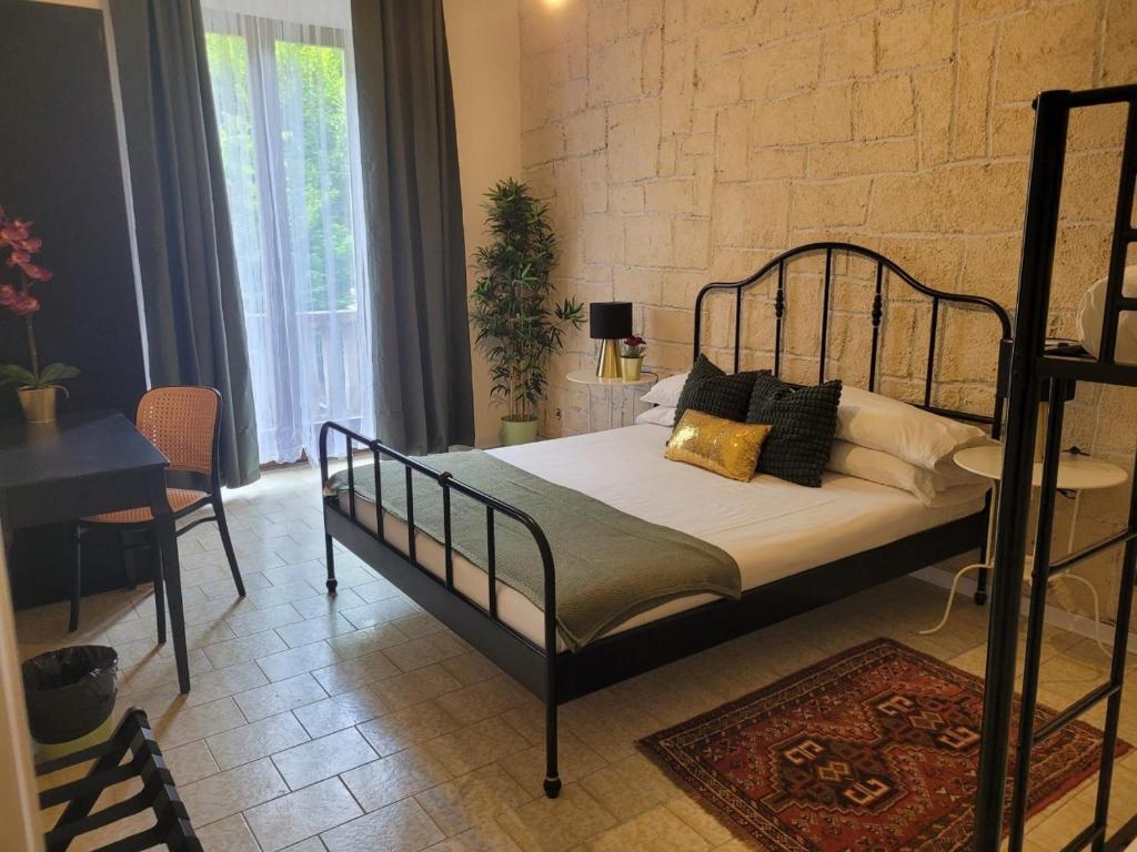 a bedroom with a bed with a black frame and a table at Ambra Boutique Hotel in Milan