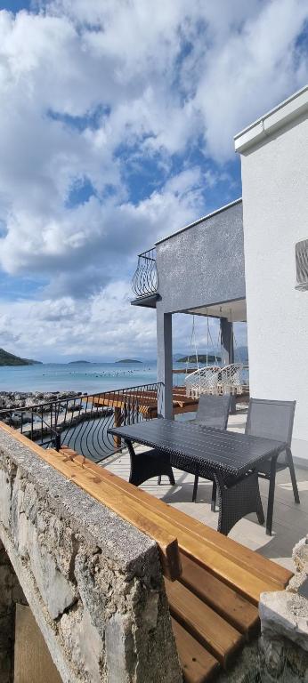 a table and benches on a patio near the beach at Private Villa by the sea in Žuljana