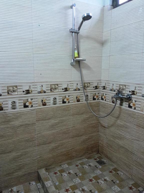 La salle de bains est pourvue d'une douche avec un tuyau. dans l'établissement Beautiful Affordable House - 5 minutes from the airport and 12 minutes to Blue bay beach, à Mon Trésor