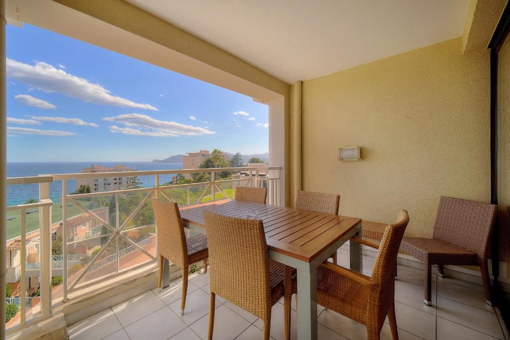 einen Balkon mit einem Tisch und Stühlen sowie Meerblick in der Unterkunft IMMOGROOM - 2BR - sea view - Swimming pool - Terrace - Parking - AC - Wifi in Cannes