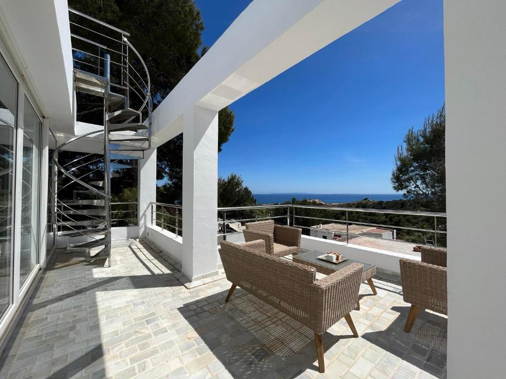 um pátio com cadeiras e uma mesa num edifício em 2b room house with sea view hidromassage and bbq em Talamanca