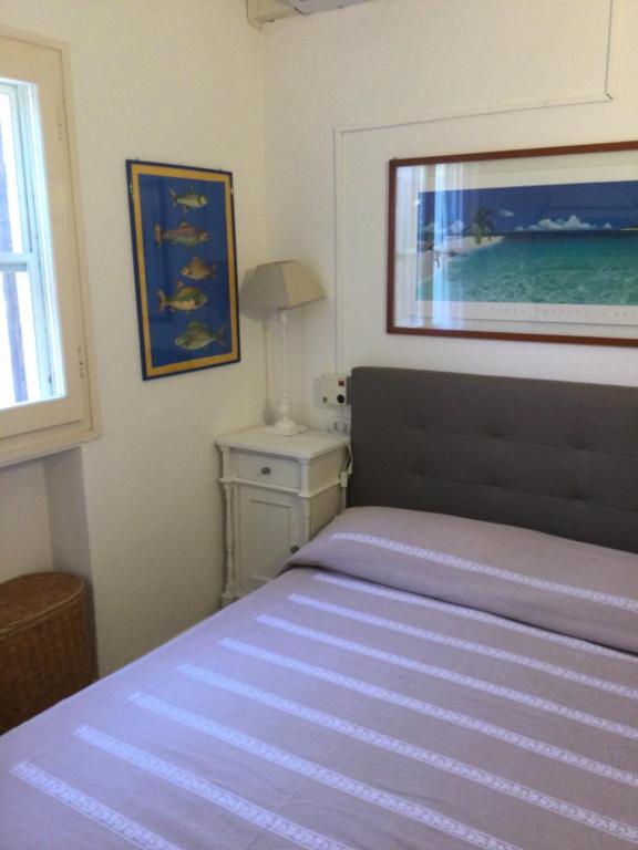 a bedroom with a bed and a picture on the wall at Villa Vera trifamigliare con ingresso diretto 20 mt al mare clima wi-fi bbq in Cala Liberotto