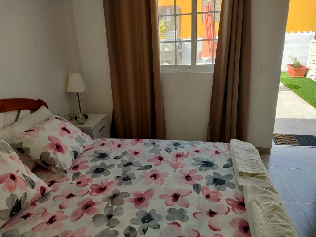 um quarto com uma cama com flores em Casa Alba 2 em Puerto del Rosario