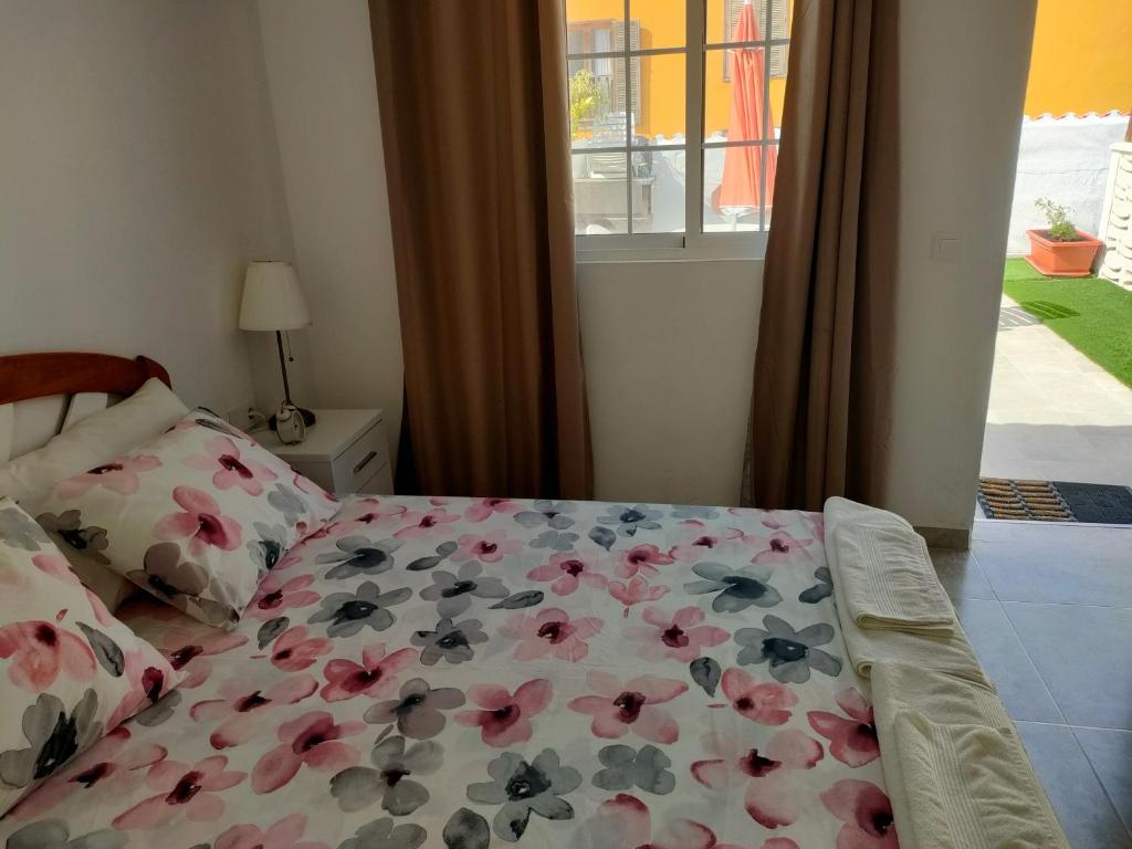 een slaapkamer met een bed met bloemen erop bij Casa Alba 2 in Puerto del Rosario