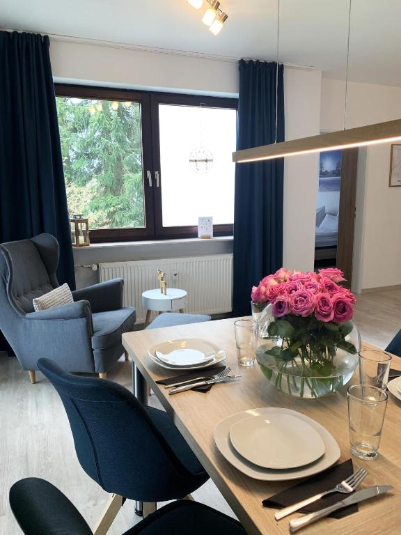 a dining room with a table with roses on it at Winterberg Appartement 21114 in Winterberg