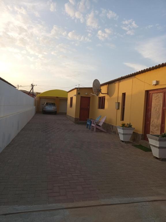 parking dwóch budynków z zaparkowanym samochodem w obiekcie Scholtz Self-catering Accommodation w mieście Lüderitz