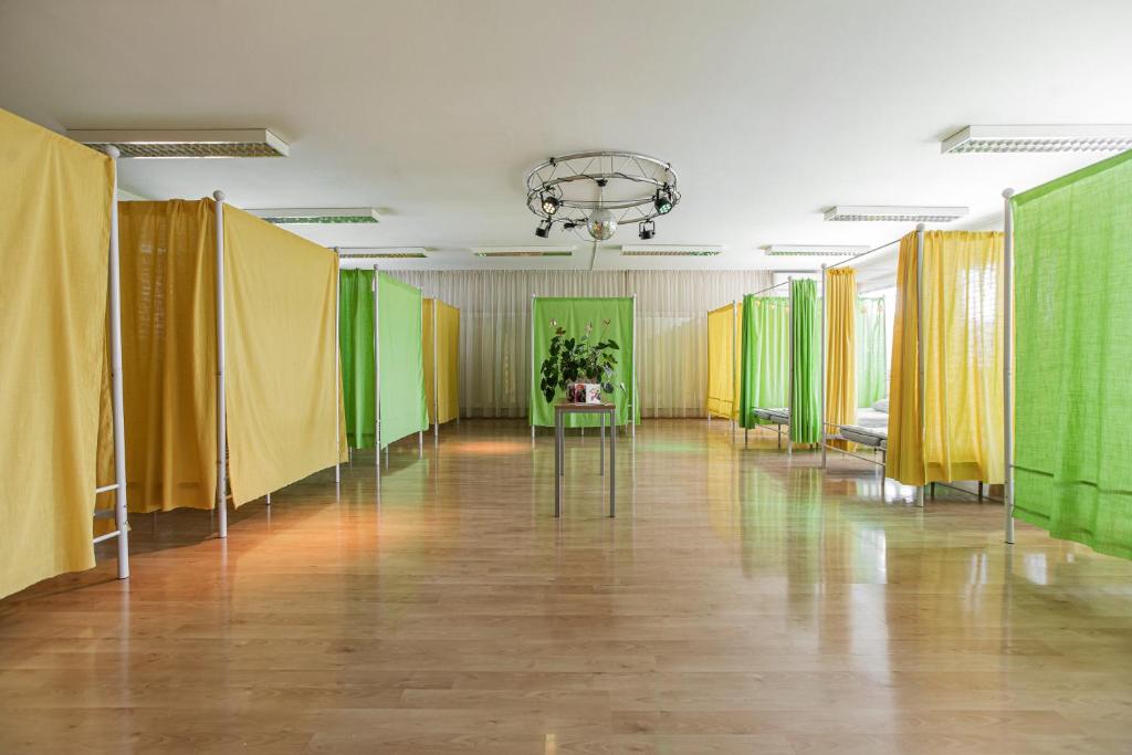 a large room with yellow and green partitions at TEJ HOSTEL in Ljubljana
