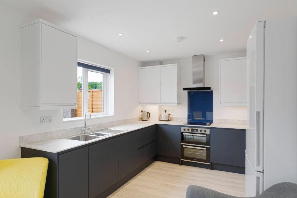 - une cuisine avec des placards blancs et un évier dans l'établissement Grayle House by Cliftonvalley Apartments, à Bristol