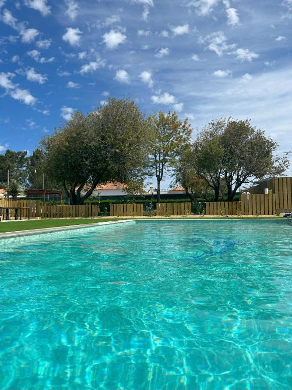 una gran piscina azul con una valla de madera en Quinta da Boavista, en Vila Nova de Milfontes