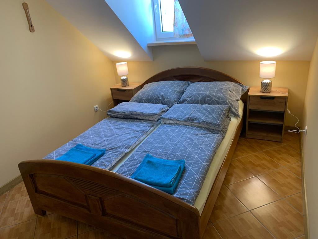 Ce lit se trouve dans un dortoir doté de 2 oreillers bleus. dans l'établissement Apartament Iwona, à Mrągowo