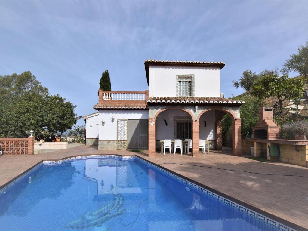 una villa con piscina di fronte a una casa di Belvilla by OYO Villa Mariposa ad Arenas