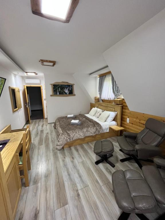 1 dormitorio con 1 cama, escritorio y sillas en Rustic Inn River en Lagos de Plitvice