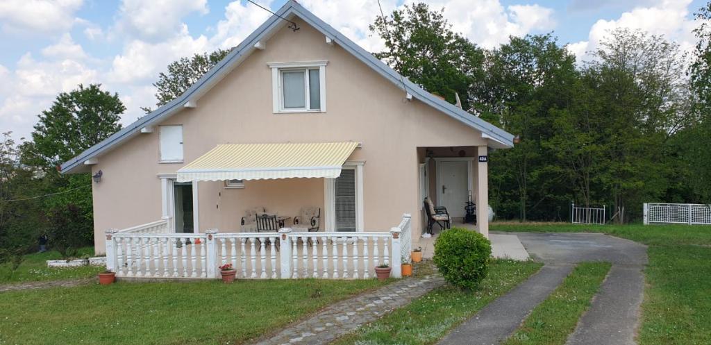 ein kleines weißes Haus mit einem weißen Zaun in der Unterkunft Holiday home - Bogi 1 in Belgrad