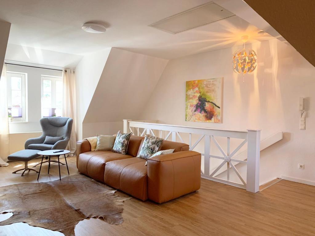ein Wohnzimmer mit einem Sofa und einem Stuhl in der Unterkunft Ferienwohnung am Südwall All INCLUSIVE in Celle