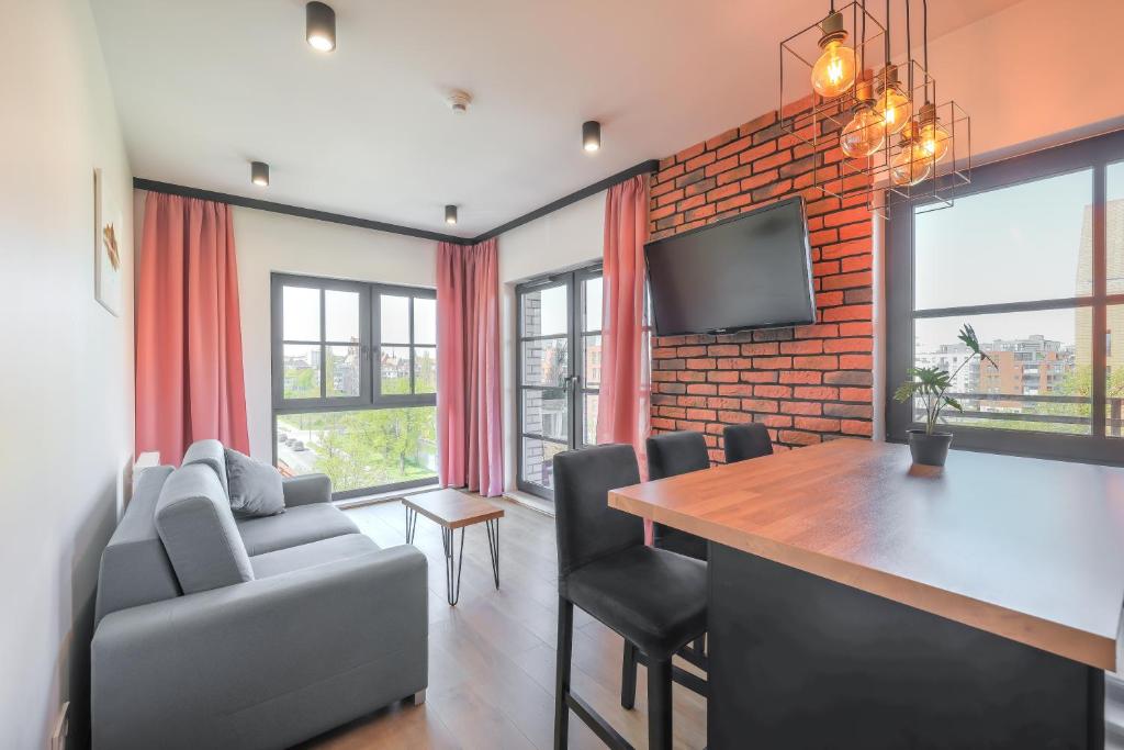 a dining room with a table and chairs and a tv at Apartament Gdańsk Śródmieście z widokiem na Motławę in Gdańsk