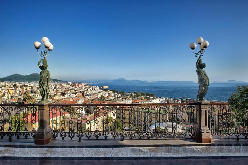 ナポリにあるグランド ホテル パーカーズの2つの像があるバルコニーから市街の景色を望めます。