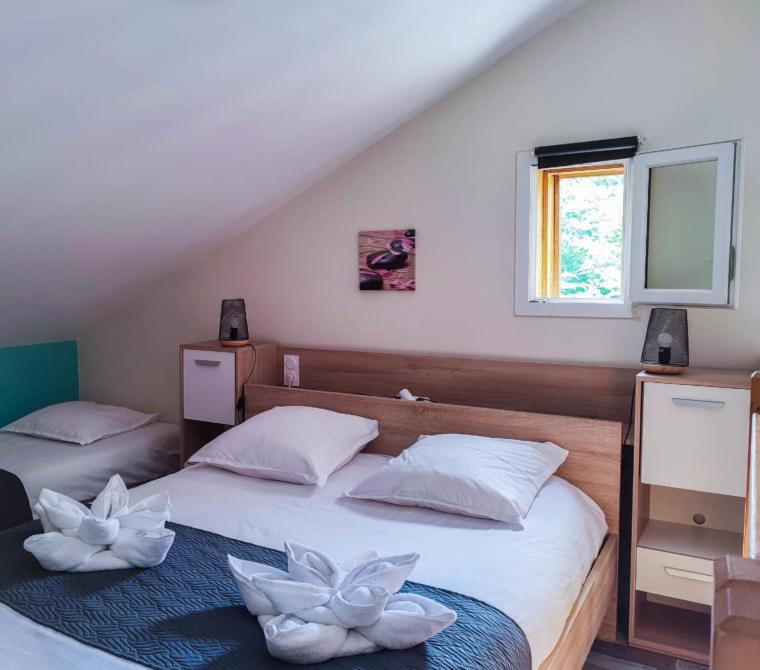 a bedroom with two beds with white flowers on them at Village Drôles d&#39;Oiseaux in Le Teich