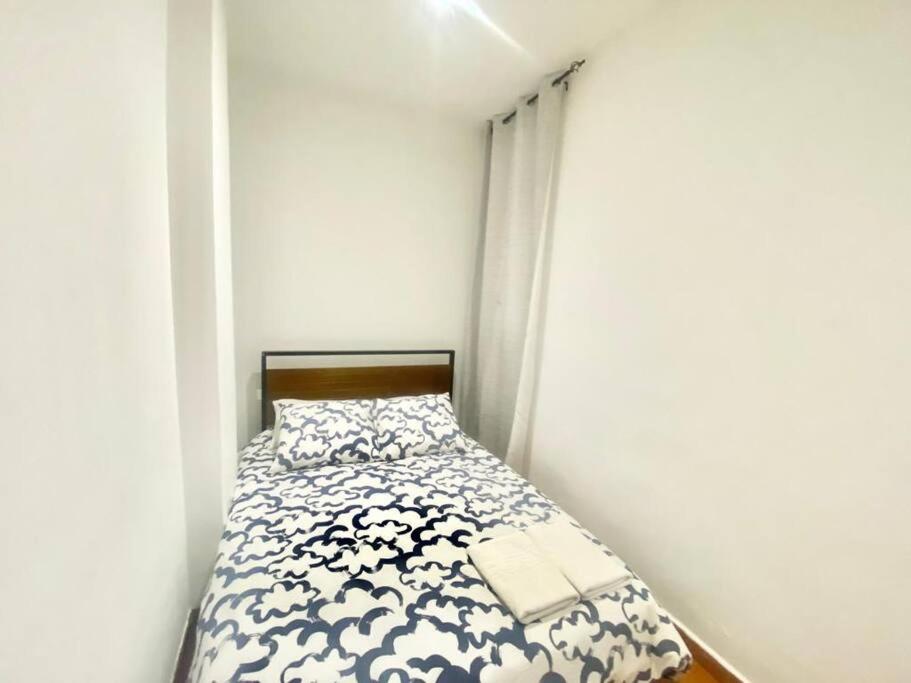 a small bedroom with a bed in a white room at Atocha ferrocarril 4 in Madrid