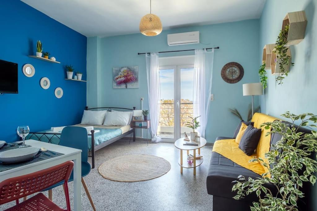 a living room with blue walls and a couch at Blue Suite Manos, in Heraklion in Heraklio