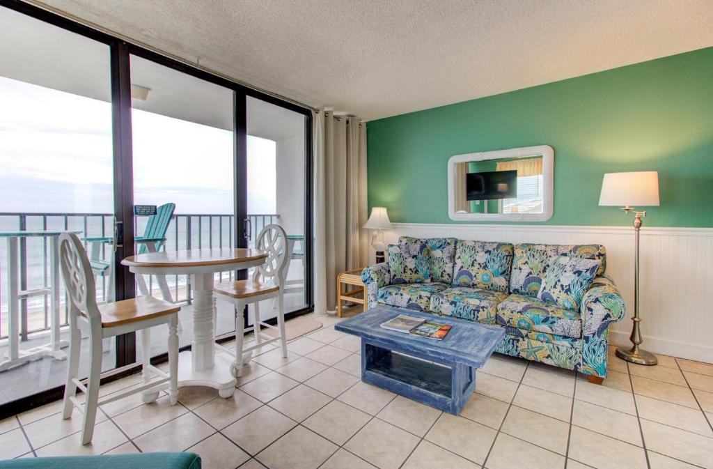 una sala de estar con un sofá y una mesa en 0701 The Green Starfish by Atlantic Towers, en Carolina Beach