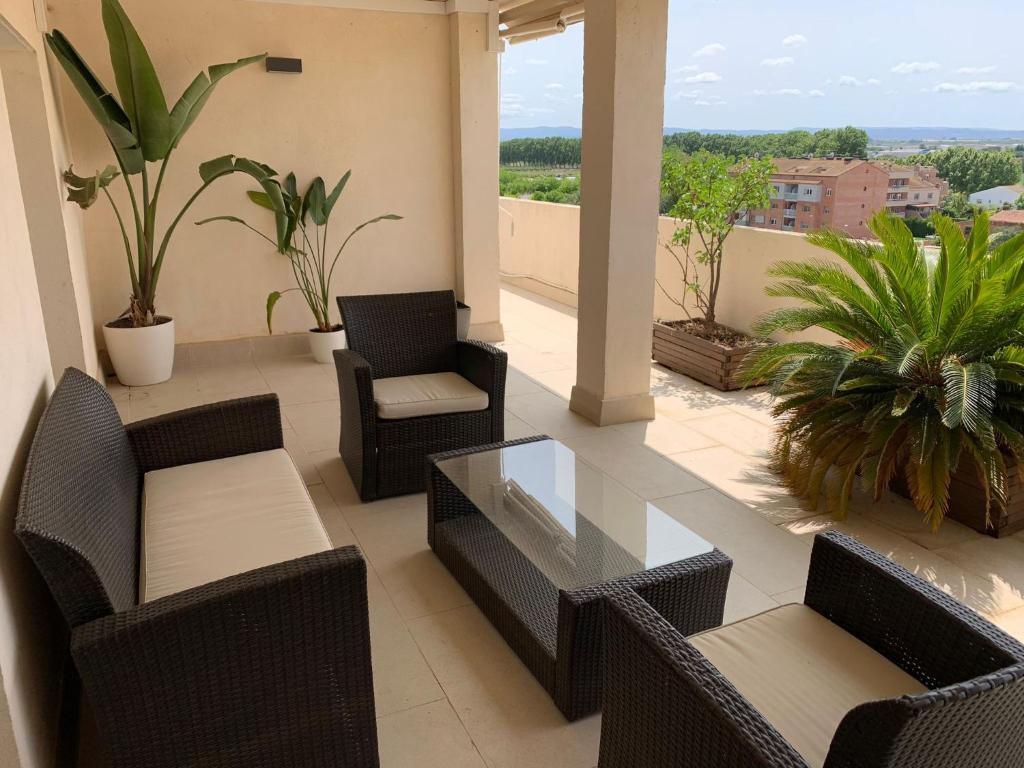 een balkon met stoelen en een glazen tafel bij La Pau Apartaments in Mollerusa