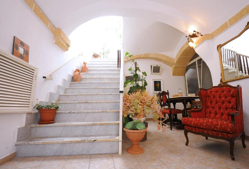ガリポリにあるPalazzo Rocci Roomsの赤い椅子とテーブルのある家の階段