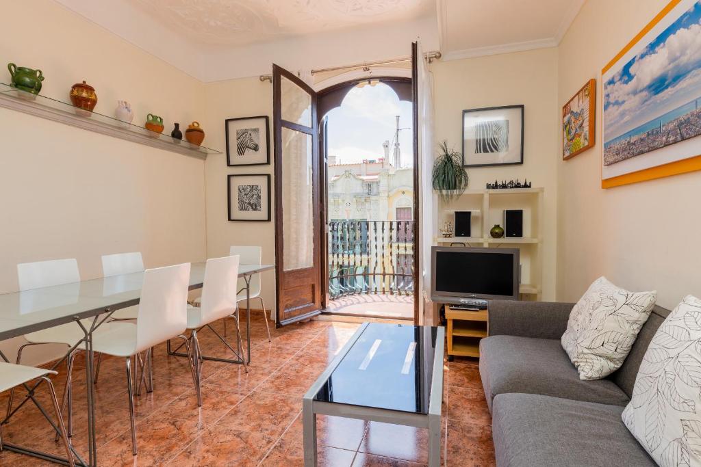 a living room with a couch and a table at ApartEasy - Modernist flat in Eixample center in Barcelona