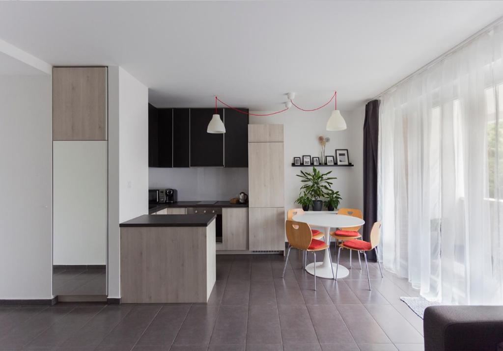 a kitchen and dining room with a table and chairs at Dobó Apartman in Szeged