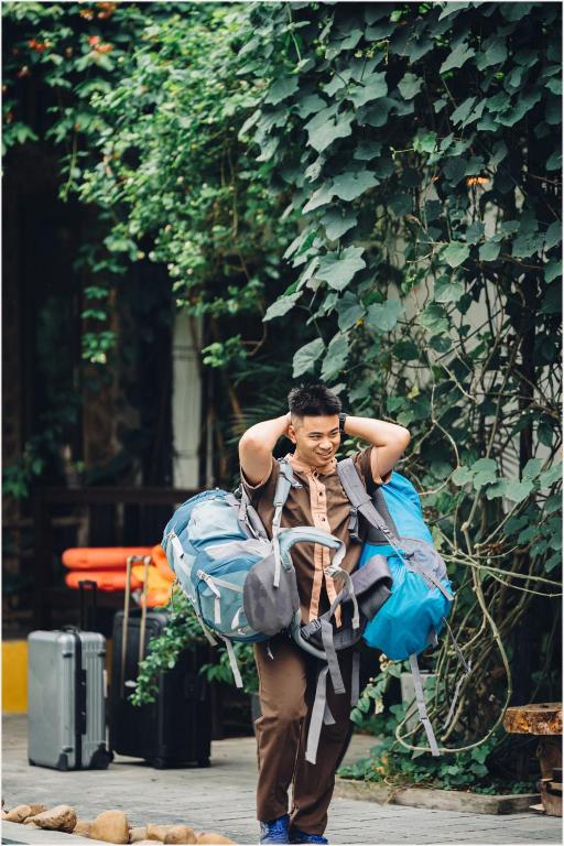 a man is carrying a bag of luggage at Trang An Ecolodge in Ninh Binh