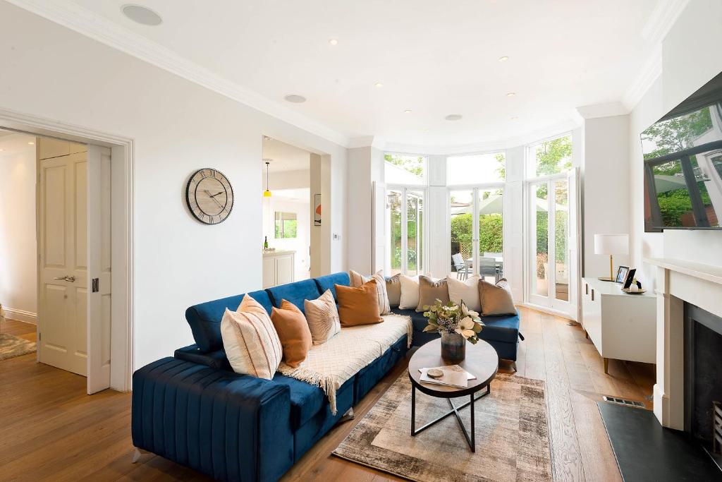 un soggiorno con divano blu e tavolo di Beautiful Regents Park Apartment a Londra