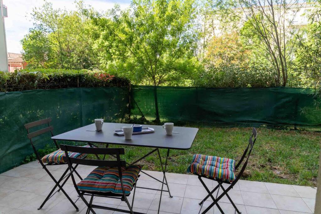 une table et deux chaises assises sur une terrasse dans l'établissement Appartement Avignon Garage-Spacieuse Terrasse, à Avignon