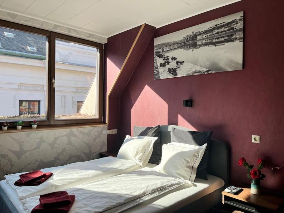布達佩斯的住宿－Central stylish apartment with shared rooftop terrace and jacuzzi，一间卧室设有一张床和两个窗户。