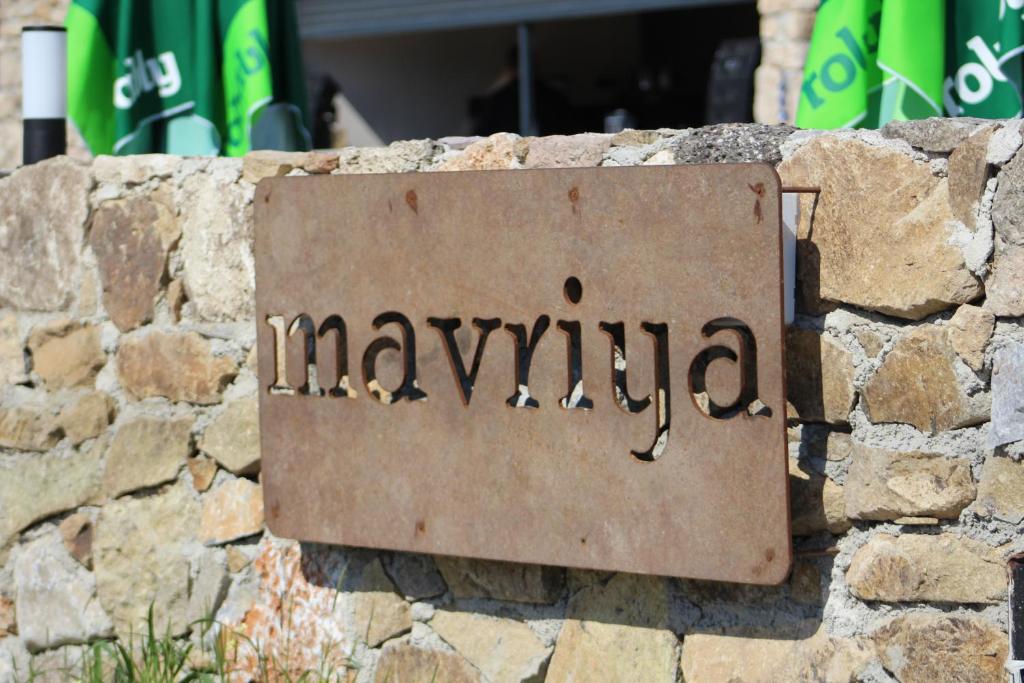 un panneau sur un mur en pierre avec le mot navinia dans l'établissement Mavriya, à Geyikli