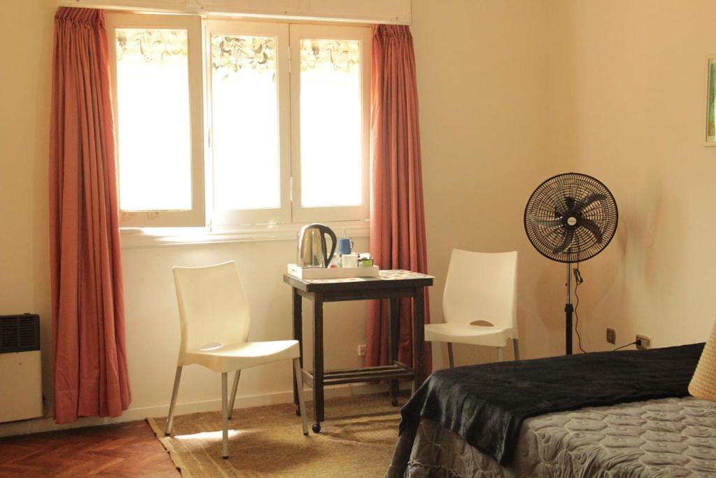1 dormitorio con 1 cama y escritorio con ventilador en La Morada - Dean Funes en Salta