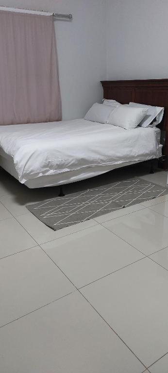 a bed in a bedroom with a tiled floor at Special Inn Bed and Breakfast in Windhoek