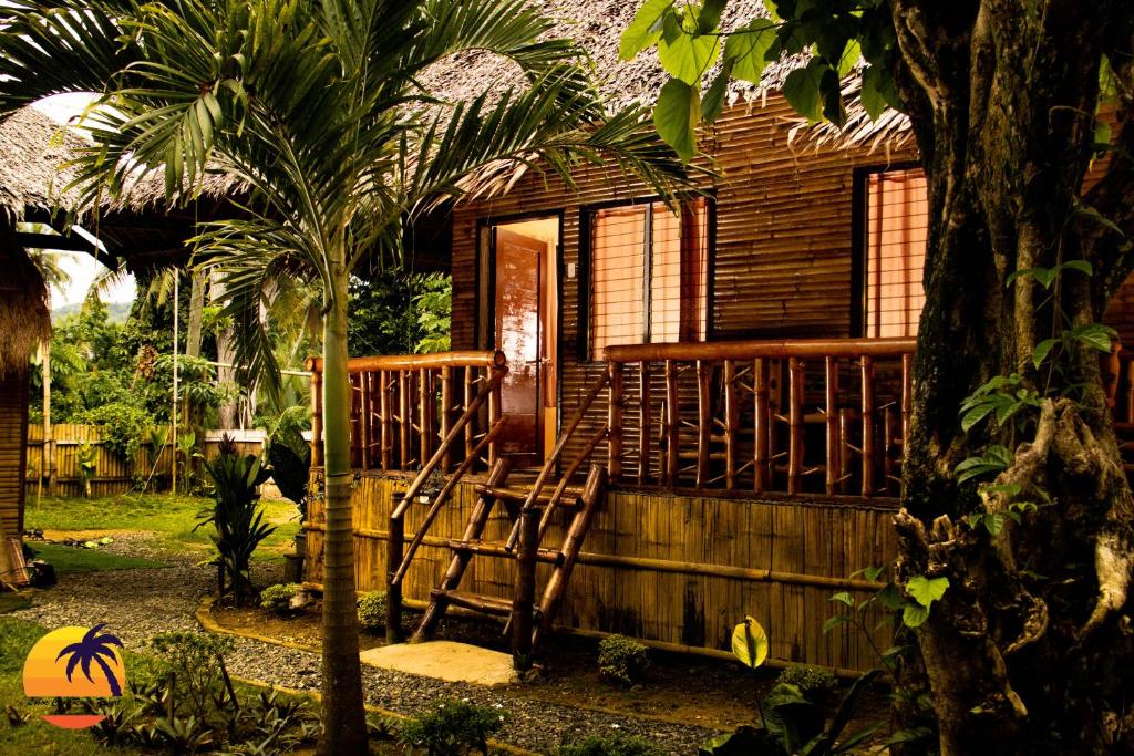 a wooden house with a porch and a chair outside at Loboc Cool River Resort in Loboc