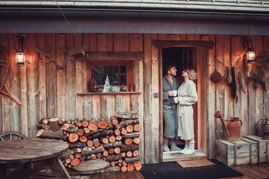 a man and woman standing in the doorway of a cabin at Chalet trappeur in Le Biot
