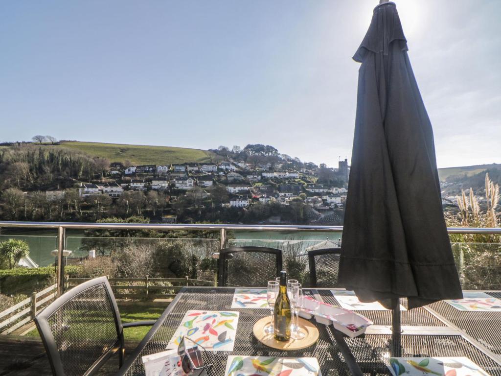 une terrasse avec une table et un parasol dans l'établissement Estuary View, à Plymouth