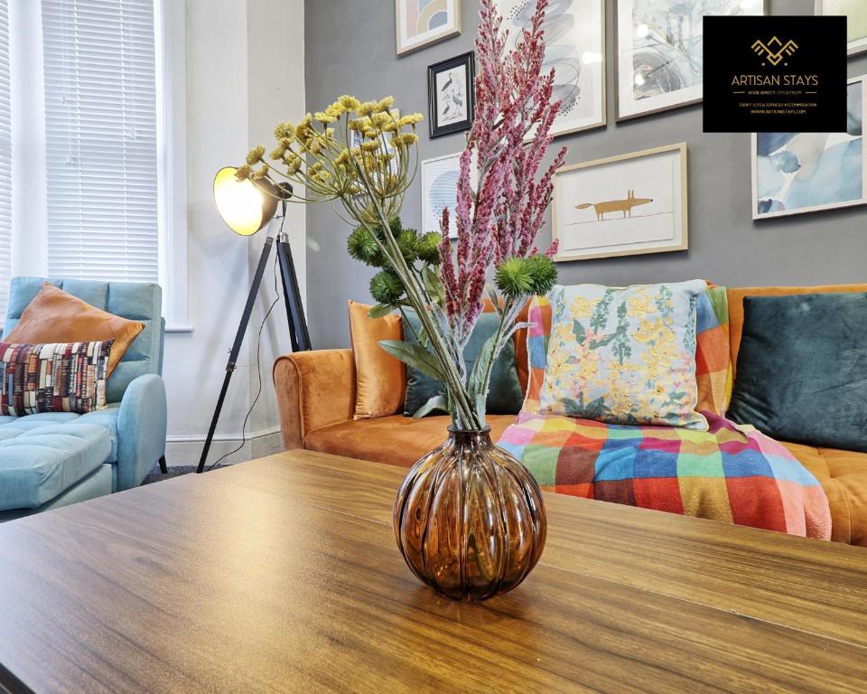 a vase with flowers on a table in a living room at Vintage Vibes By Artisan Stays in Southend-On-Sea I Free Parking I Contractors & Families I Sleeps 5 in Southend-on-Sea