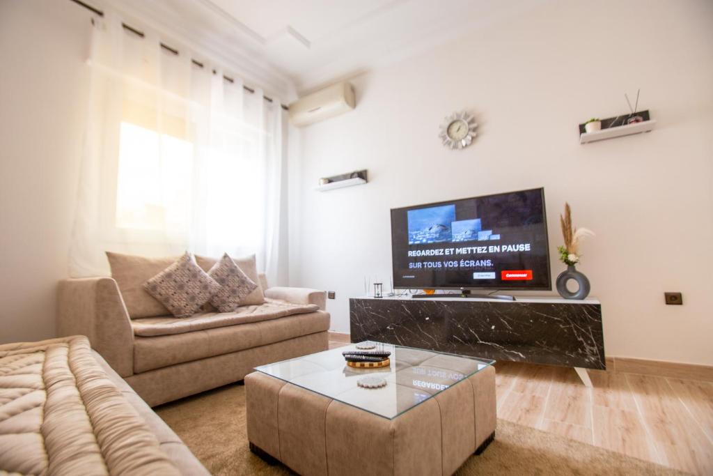 a living room with a couch and a tv at Appartement Ensolleillé Au coeur De Tanger in Tangier